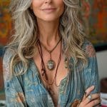 Smiling person with gray hair in a floral shirt.