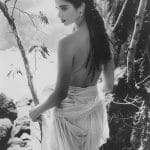 Woman in flowing dress near rocky landscape