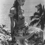Woman in patterned dress by the sea
