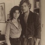 Vintage photo of two people posing together inside.