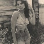 Woman in vintage clothing outdoors, black and white photograph.