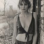 Black and white portrait of person leaning on wall.