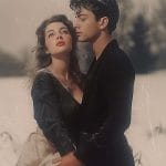 Vintage-style couple embracing in snowy outdoors.