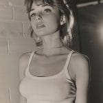 Black and white photo of woman in tank top.