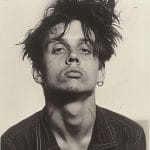 Young man with tousled hair posing confidently.