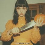 Person holding knife and pumpkin indoors.