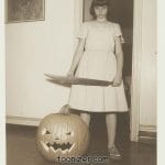 Child with sword and carved pumpkin indoors