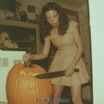 Woman carving large pumpkin with serrated knife