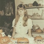 Girl with pumpkins in a spooky Halloween setting.