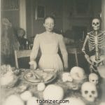 Victorian woman dining with skeletons and skulls.