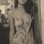 Woman in floral dress, vintage setting, black and white.