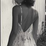 Woman in floral dress near wooden building