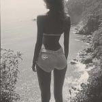 Silhouette of person overlooking ocean cliffs.