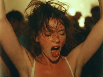 Woman dancing energetically with arms raised at party