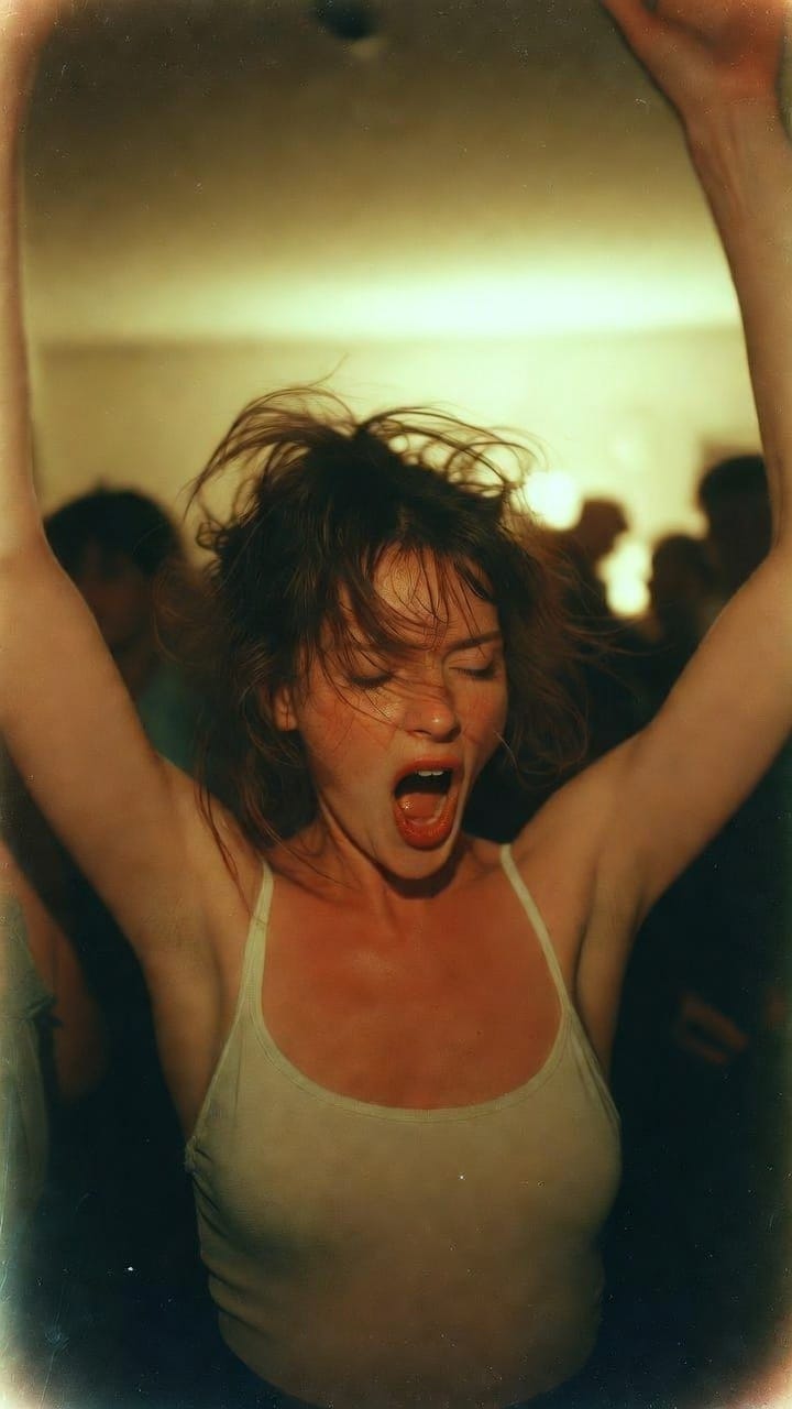 Woman dancing energetically with arms raised at party