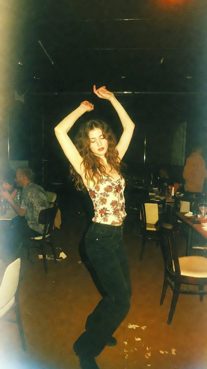 Woman dancing in dimly lit restaurant