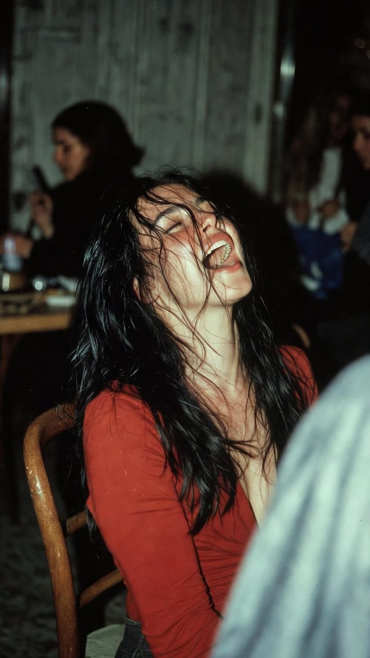 Woman laughing with wet hair in dim bar