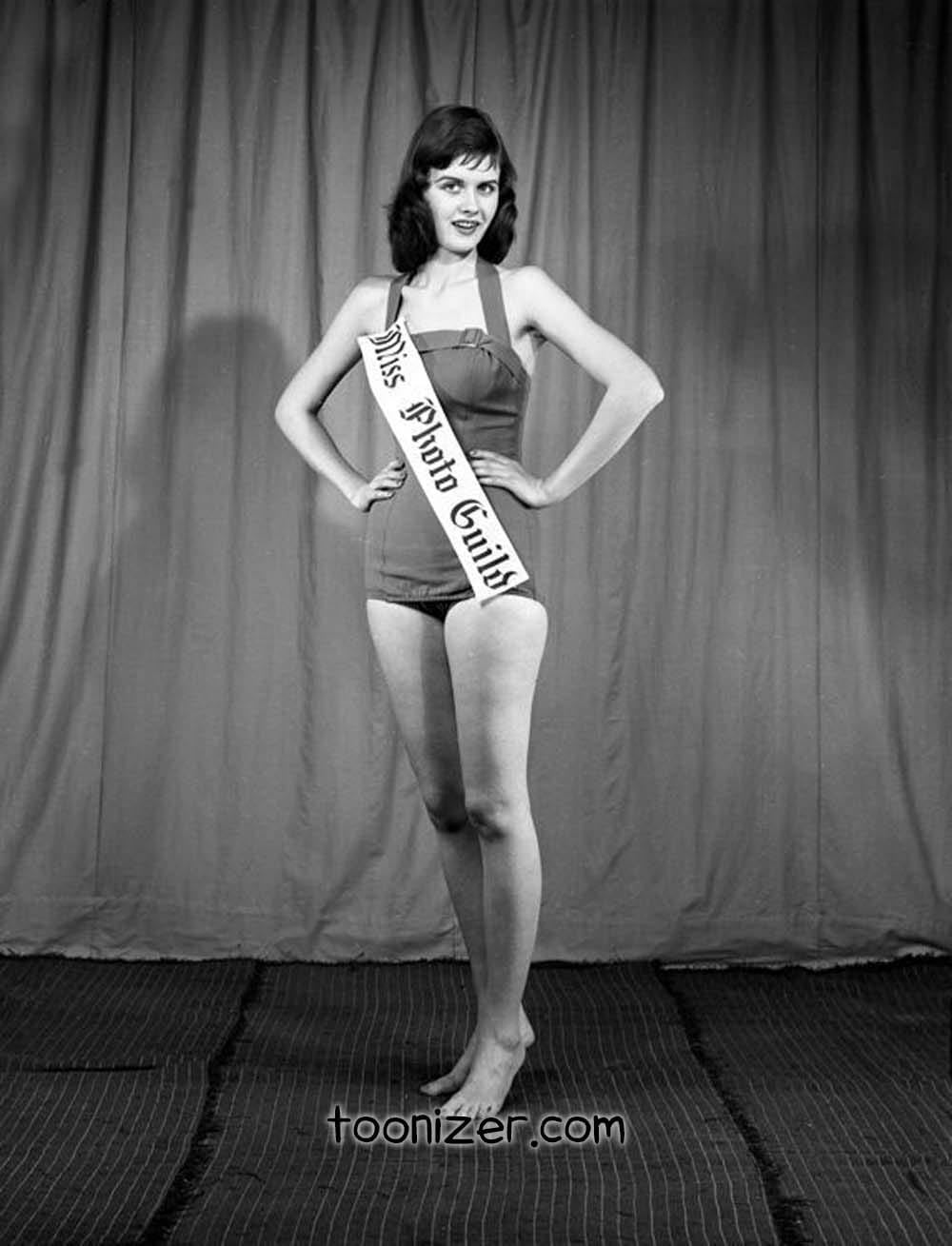 Woman in vintage swimsuit with sash, 1950s style.