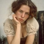 Young woman resting chin on hand indoors