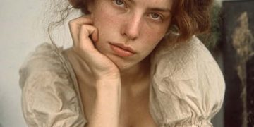 Young woman resting chin on hand indoors
