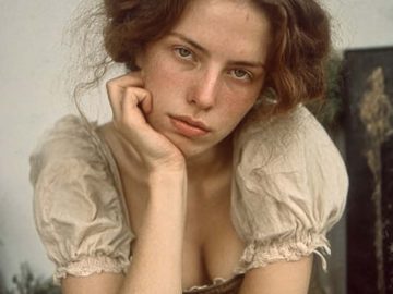 Young woman resting chin on hand indoors