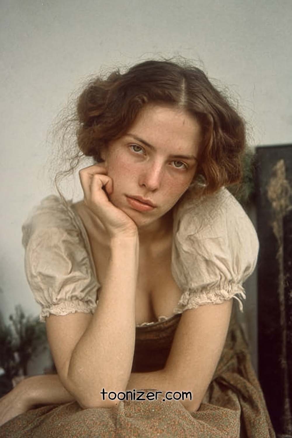 Young woman resting chin on hand indoors