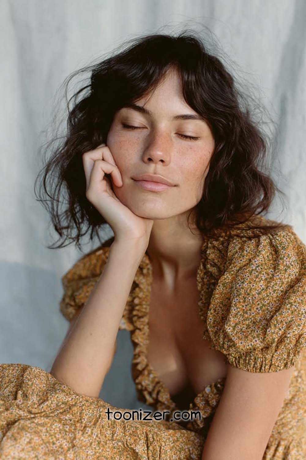 Woman with closed eyes, resting her head on hand.