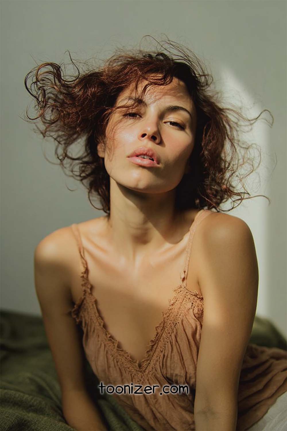 Woman with curly hair in brown top