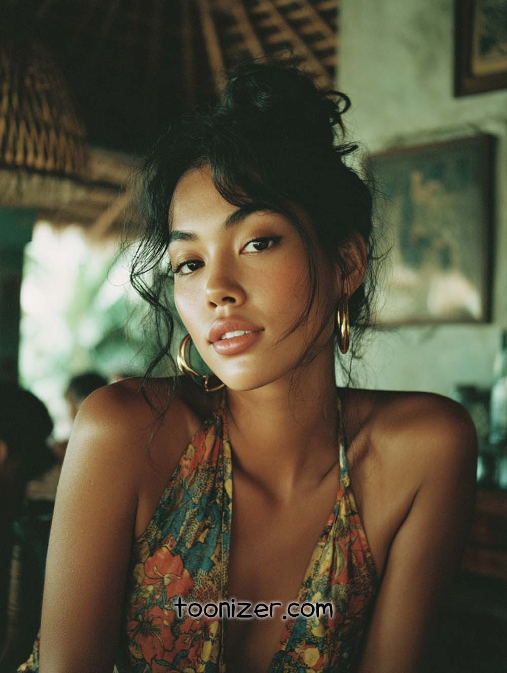 Person in colorful dress with gold earrings.