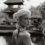 Woman in floral dress near water, black and white