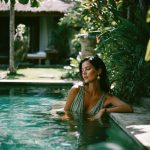 Woman relaxing in a lush garden pool