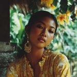 Woman in yellow dress with floral background.