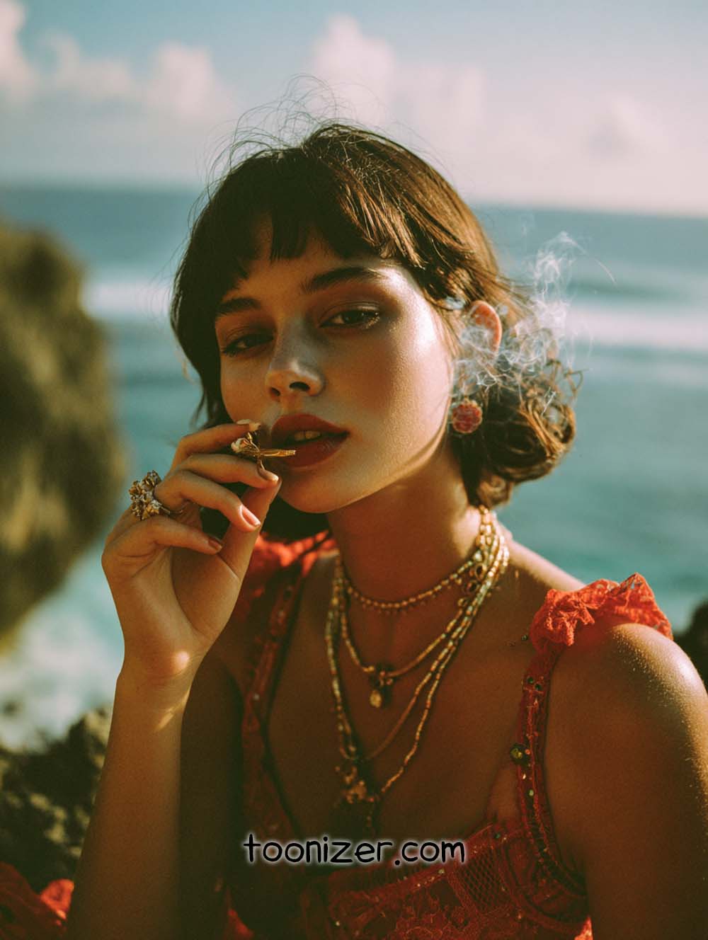 Woman in red dress smoking by the sea