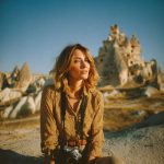 Woman with camera in rocky landscape