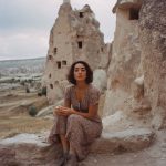 Woman sitting in rocky landscape, Cappadocia background.
