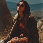 Woman outdoors in bohemian outfit and sunglasses.