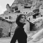 Woman in rocky landscape, wearing dark outfit