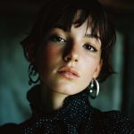 Person with earrings and polka dot shirt.