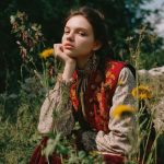 Woman in vintage dress sitting in wildflowers