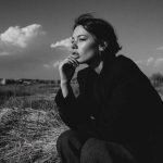 Pensive person outdoors in black and white photo.