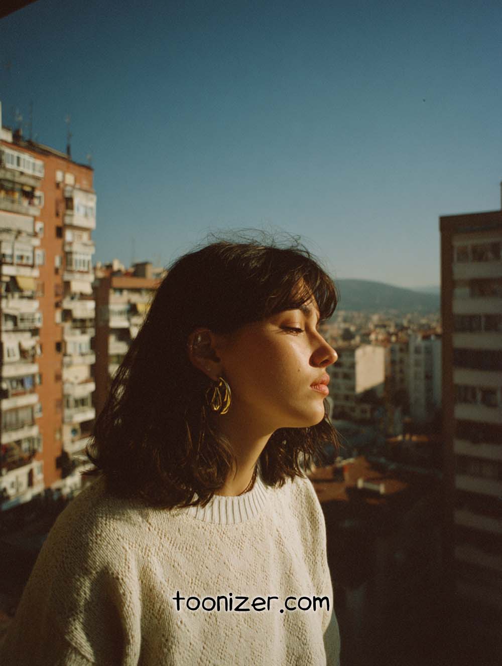 Woman enjoying sunlight on urban balcony