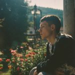 Person sitting in garden during sunset.