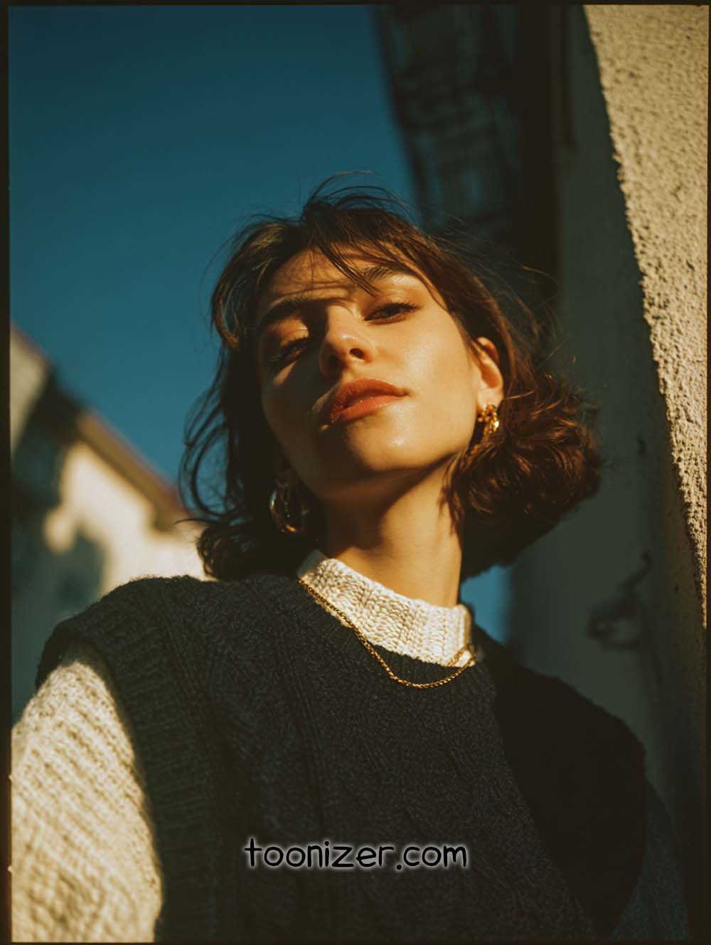 Person basking in sunlight, wearing knit sweater.