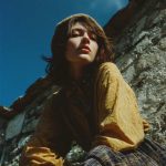 Person in vintage plaid outfit under blue sky