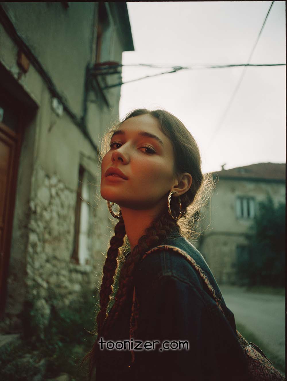 Person with braids in urban setting, sunset backdrop.