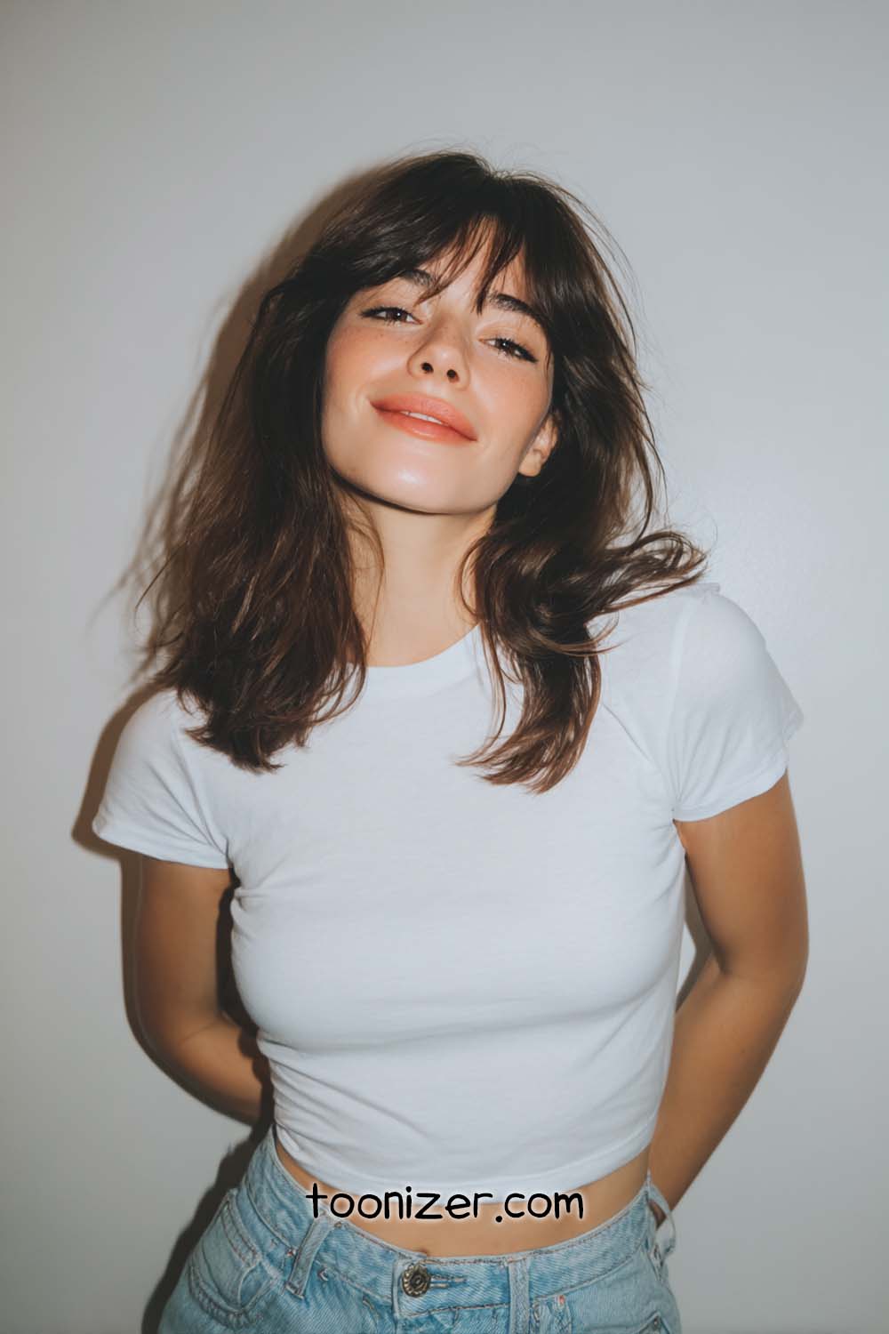 Smiling person in white shirt and jeans