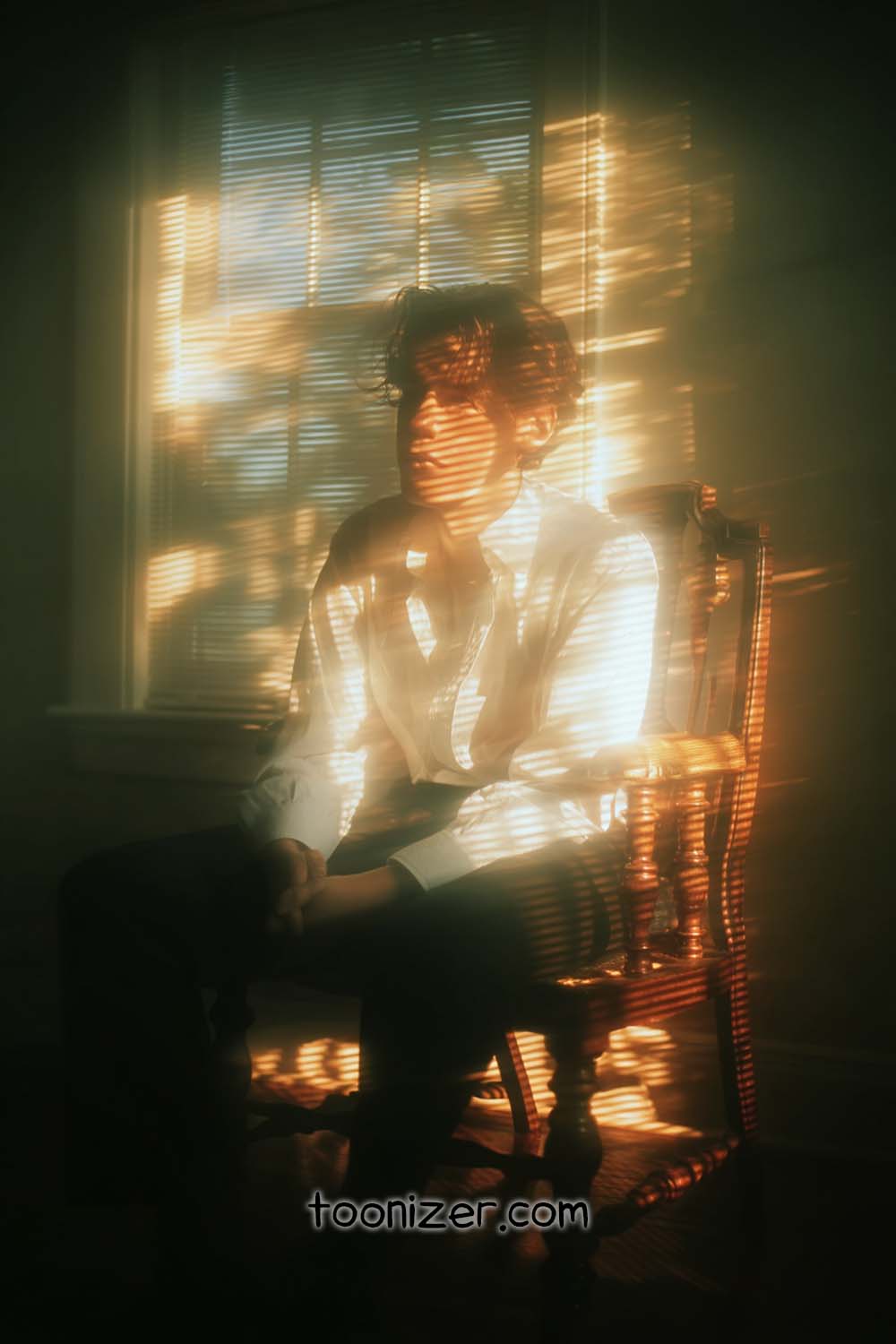 Person in chair with sunlight patterns indoors.