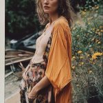 Woman in floral outfit, standing outdoors.