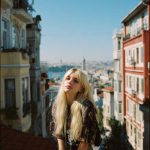 Woman sitting on urban balcony with city view