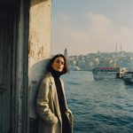 Person standing by the water in winter clothing